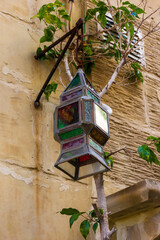 Rustic Stained Glass Lantern Hanging Near A Wall With Ivy Vine
