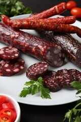 Different smoked sausages and spices on table, closeup