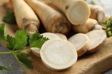 Parsley roots and leaves on grey table, closeup