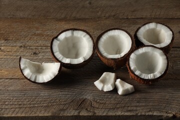 Pieces of cracked coconuts on wooden table