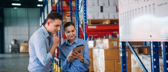 Warehouse worker working and checking the stock in the warehouse. .Factory manager using digital...
