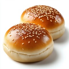 Two golden brown burger buns with sesame seeds on a white background in a studio shot with soft lighting