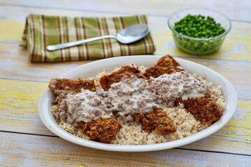 chicken fried steak topped with sausage gravy on a bed of rice