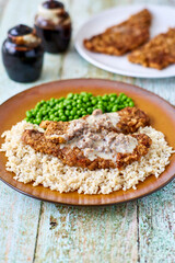 chicken fried steak on a bed of rice served with peas
