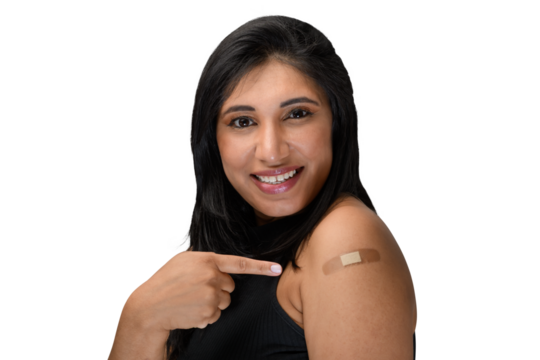 woman points to the vaccine sticker on her arm

