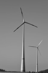 Fototapeta premium Wind farm with wind turbines or wind mills provide renewable electricity, black and white picture