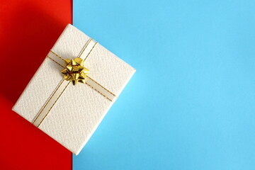 A small gift box lies on a blue background.	