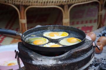 Cooking eggs over open fire outdoor kitchen food photography rustic environment close-up culinary tradition