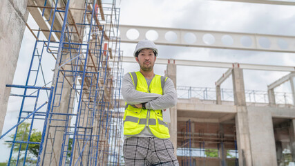 Two Asian engineer working at site of a large building project,Work overtime at construction site,Team of engineer discus at site,The architect, supervisor, and foreman meet to discuss the design