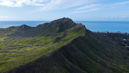 Aerial View of Diamond Head Crater in Honolulu. Stunning aerial view of Diamond Head Crater in Honolulu, Hawaii, showcasing lush green slopes, the Pacific Ocean, and the city skyline.