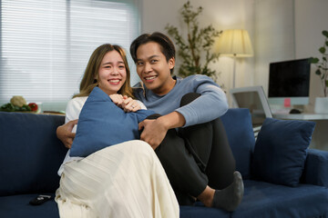 Happy couple relaxing on a cozy sofa at home