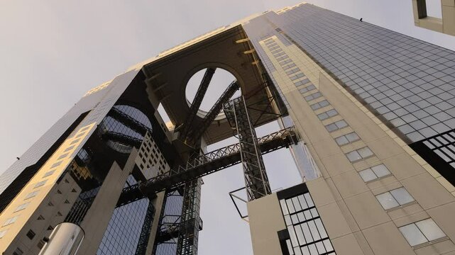 Umeda Sky Building in Osaka Japan and sunlight in evening. Landmark features a unique floating garden observatory connecting twin towers at top. Umeda Sky Building One of Osaka Landmark travel spot.