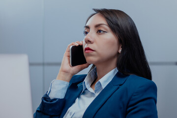 Mujer latina de negocios en llamada telefónica en la oficina