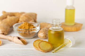 Ginger essential oil on texture background. Fresh ginger slices. Essence, serum, oil. Alternative...