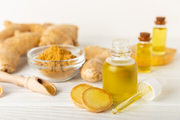 Ginger essential oil on texture background. Fresh ginger slices. Essence, serum, oil. Alternative medicine. Phytotherapy. Health and beauty concept. Place for text. Copy space.
