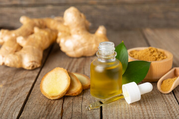 Ginger essential oil on texture background. Fresh ginger slices. Essence, serum, oil. Alternative...