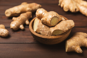 Fresh ginger on wooden background. Dry ginger. Sliced ​​ginger with honey and lemon. Ginger...