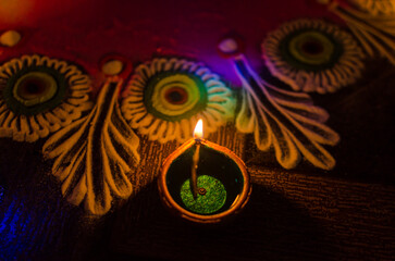Happy Diwali festival with Lighting oil diyas and lamps near colorful rangolis