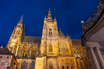 St Vitus Cathedral stands majestically beneath the night sky, glowing softly with golden lights.