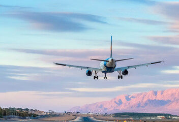 Landing civil jet aircraft in desert area of the Middle East, seen runway and surrounding mountains...