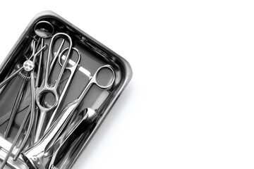 Professional medical equipment - surgery stainless metal instruments in tray on white background....