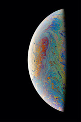 A black background with half of a soap bubble. Bright, colorful fantastic patterns.