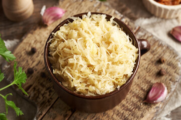 Fermented white cabbage or sauerkraut in a brown pot