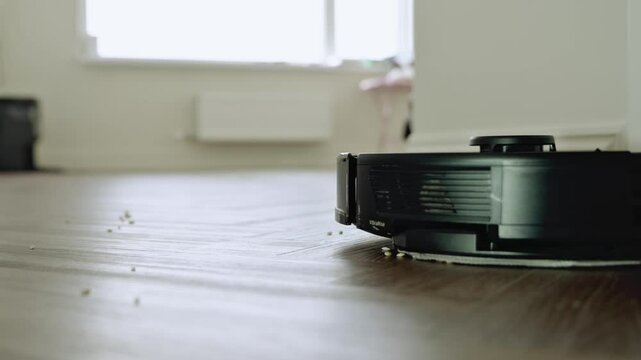Robot vacuum cleaner vacuuming the floor in the bedroom. Smart home with automated devices that simplify life. A smart vacuum cleaner cleans the floor. High quality 4k footage