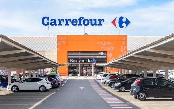 Dos Hermanas, Seville, Spain, 02-15-2025; Carrefour logo sign on the main entrance of a supermarket and parking for customers.