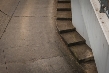 Stairway leading down a curved path in an urban setting with concrete textures in the late...