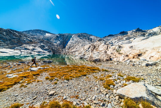 Woman Walking Along Alpine Lake Shore