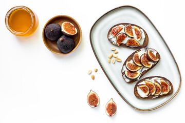 Breakfast with figs and cheese toasts with honey, top view