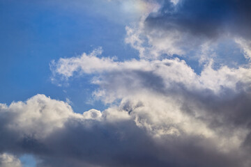 Gray clouds fill the sky, creating a striking and dramatic landscape. The depth and texture of the clouds emphasize their volume and grandeur.