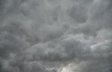 Thick gray clouds filled the sky, leaving only small glimpses of sunlight. A dramatic sky landscape filled with depth and atmospheric dynamics.