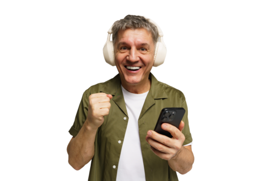 Man in green shirt celebrates while wearing headphones and holding a smartphone indoors - Powered by Adobe