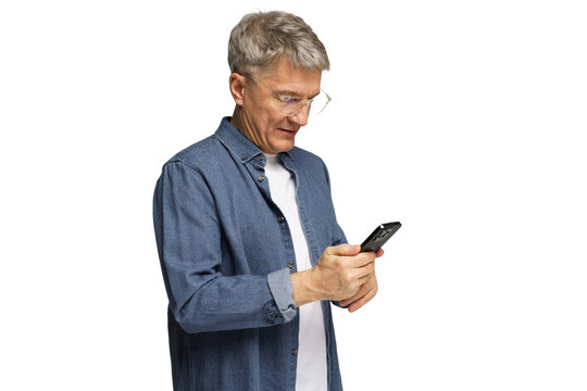 Senior man in casual outfit using smartphone while standing indoors in well-lit environment