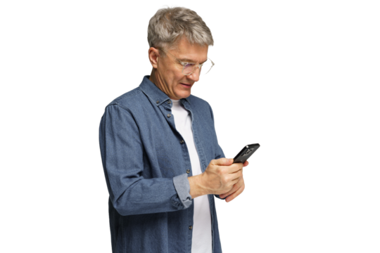 Senior man in casual outfit using smartphone while standing indoors in well-lit environment