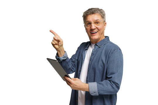 Senior man smiling and pointing while holding a tablet against a plain background