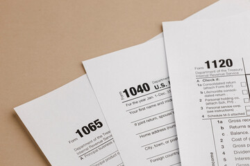 Obraz premium Tax forms 1040, 1065, and 1120 for individuals, partnerships, and corporations, essential for filing taxes.