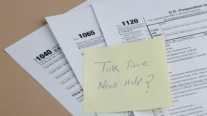 Fototapeta premium Tax season is here! Forms 1040, 1065, and 1120 suggest deadlines are approaching, and a note asking for help conveys the need for tax assistance.
