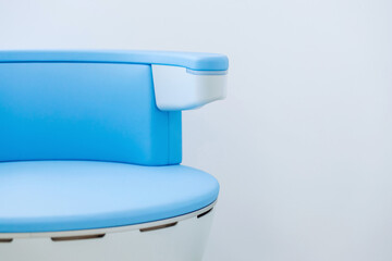 Modern waiting room in blue medical office interior with chair machine for treatment pelvic floor muscles