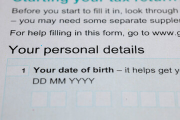 Close-up on a form requiring personal details, specifically date of birth, filled with blanks for...