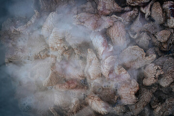 Steaming beef slices simmer in a bubbling broth, releasing rich flavors as they cook. The tender...