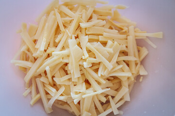 A close-up of sliced bamboo shoots in a white bowl. The fresh, pale yellow pieces are ready for use in cooking, commonly found in Asian cuisine and stir-fry dishes.
