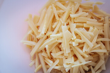 A close-up of sliced bamboo shoots in a white bowl. The fresh, pale yellow pieces are ready for use in cooking, commonly found in Asian cuisine and stir-fry dishes.
