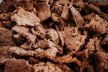 A close-up of cooked beef slices in a pan, showing their texture and slight browning. The meat appears tender and ready for further preparation or serving.