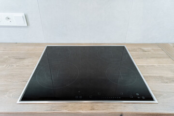 On a wooden counter, there is a black stove top oven that is prominently displayed. Its sleek...
