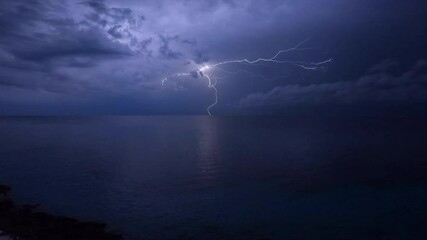 Explosive Dramatic Nighttime Lightning Storm exploding lightning bolts flashing over the ocean near the Carribbean Sea and the Gulf of Mexico - Powered by Adobe