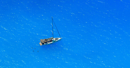 Fototapeta premium Aerial view of sailboat on turquoise waters