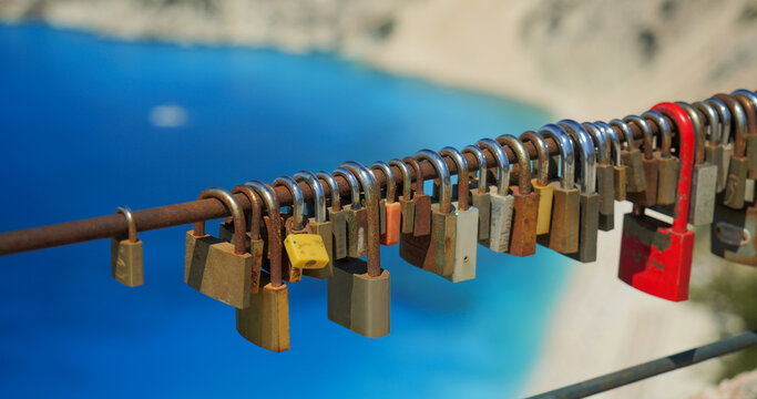 Colored love locks on a fence on top mountain above Myrtos beach in Kefalonia